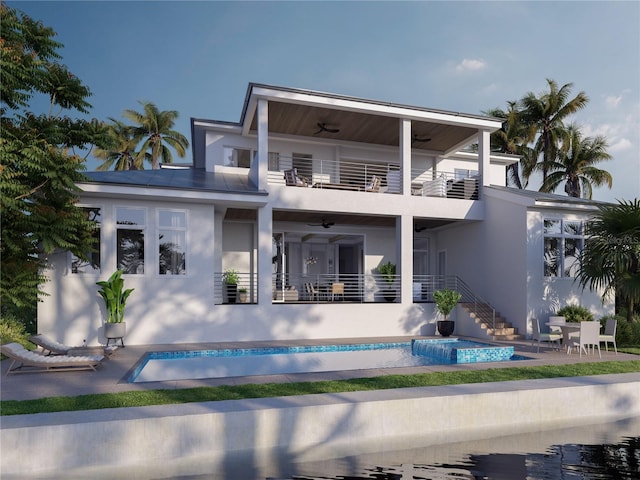 rear view of house featuring ceiling fan, a balcony, a swimming pool with hot tub, and a patio area