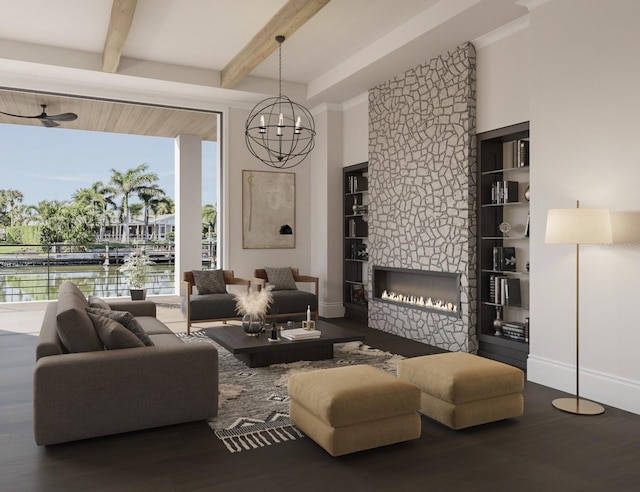 living room featuring hardwood / wood-style flooring, beam ceiling, a water view, a notable chandelier, and a stone fireplace