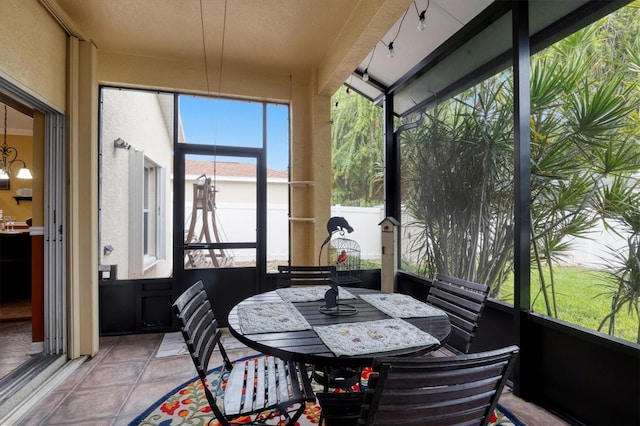 sunroom / solarium with an inviting chandelier