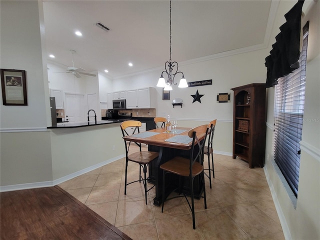 dining room with sink, ceiling fan with notable chandelier, ornamental molding, and light tile patterned flooring