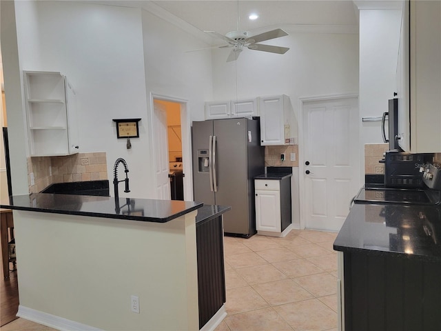 kitchen with stainless steel appliances, light tile patterned floors, high vaulted ceiling, kitchen peninsula, and white cabinets