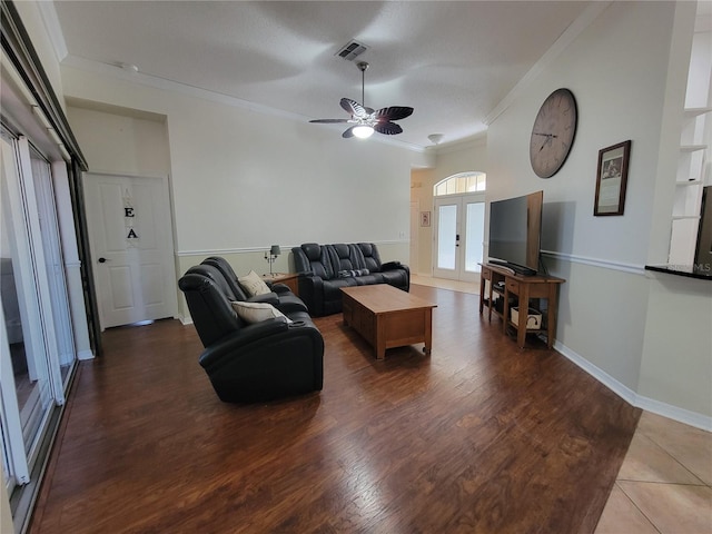 living room with french doors, crown molding, ceiling fan, and dark wood-type flooring