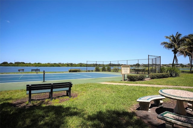 view of home's community featuring a water view, a lawn, and tennis court