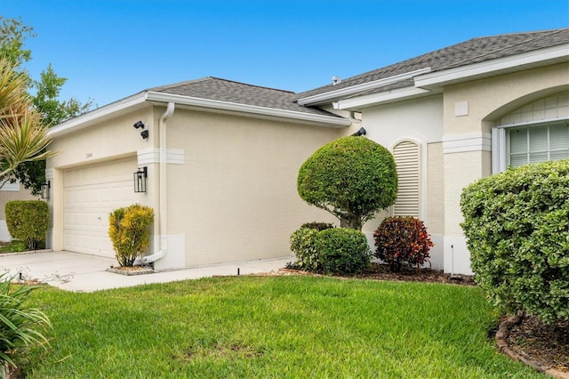 view of side of property with a garage and a lawn