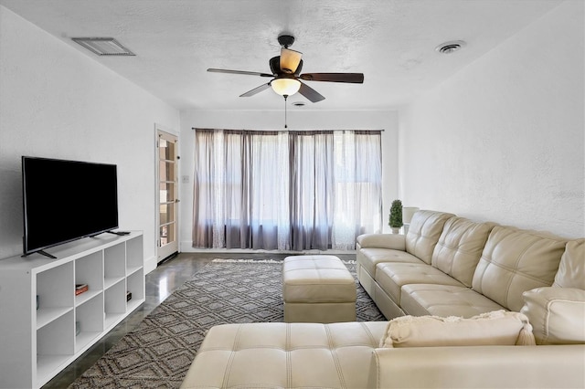 living room featuring a textured ceiling and ceiling fan