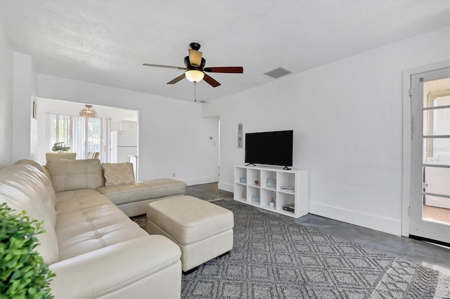 living room featuring ceiling fan and a wealth of natural light