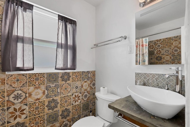 bathroom featuring vanity, toilet, and tile walls