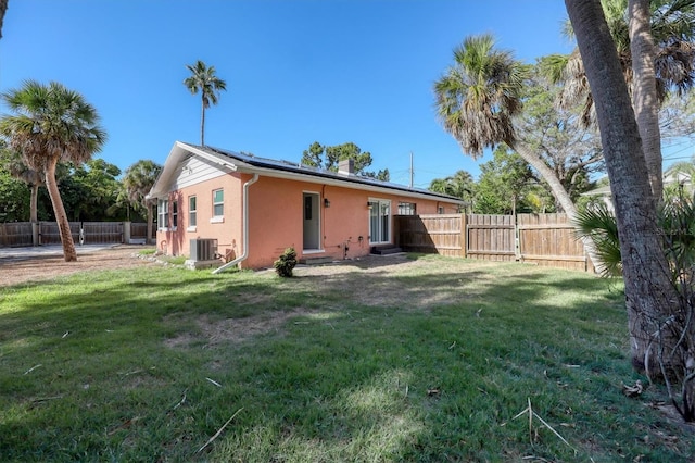 back of property with a yard and central air condition unit