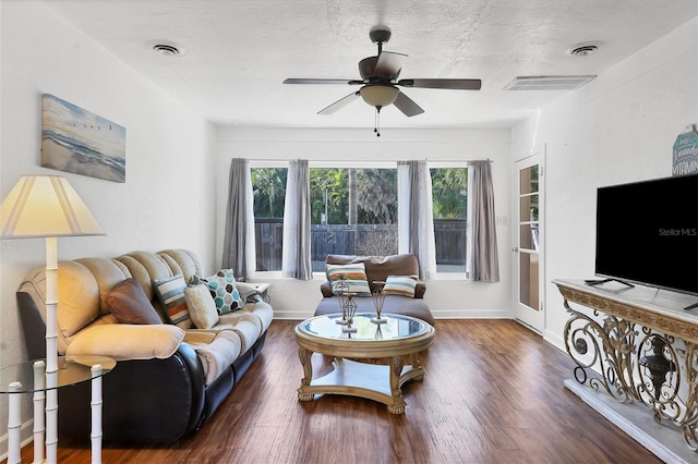 living room with ceiling fan, a textured ceiling, and dark hardwood / wood-style flooring