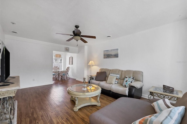 living room with dark wood-type flooring and ceiling fan