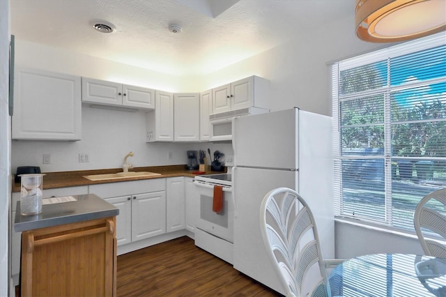 kitchen featuring dark hardwood / wood-style floors, white appliances, white cabinets, and sink