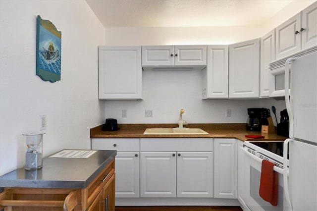 kitchen with white appliances, white cabinets, and sink