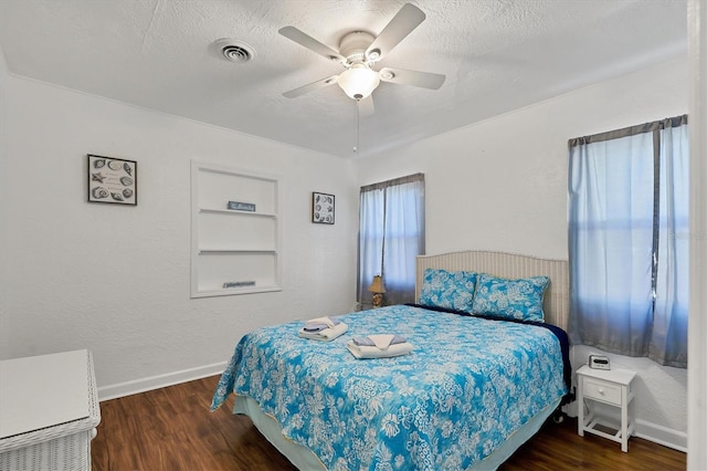 bedroom featuring dark hardwood / wood-style floors, a textured ceiling, and ceiling fan