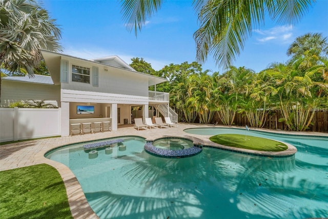 view of swimming pool featuring a patio area and an in ground hot tub