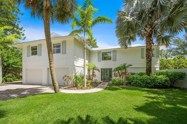 view of front of house featuring a garage and a front lawn