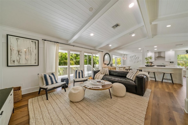 living room featuring lofted ceiling with beams and hardwood / wood-style floors