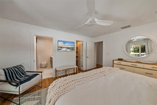 bedroom featuring ensuite bathroom, hardwood / wood-style flooring, and ceiling fan