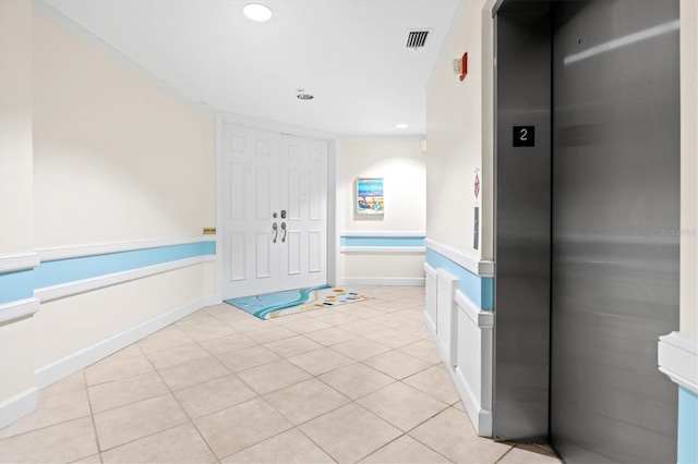 bathroom with tile patterned flooring, ornamental molding, and elevator