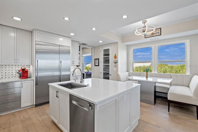 kitchen featuring light hardwood / wood-style floors, ornamental molding, sink, and appliances with stainless steel finishes