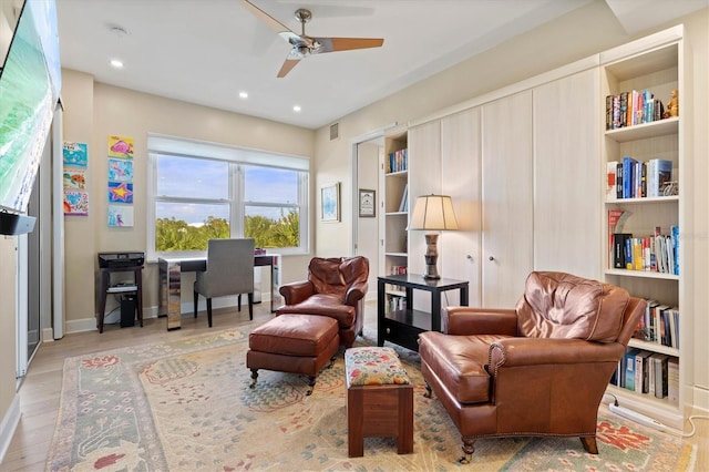 sitting room with light wood-type flooring and ceiling fan