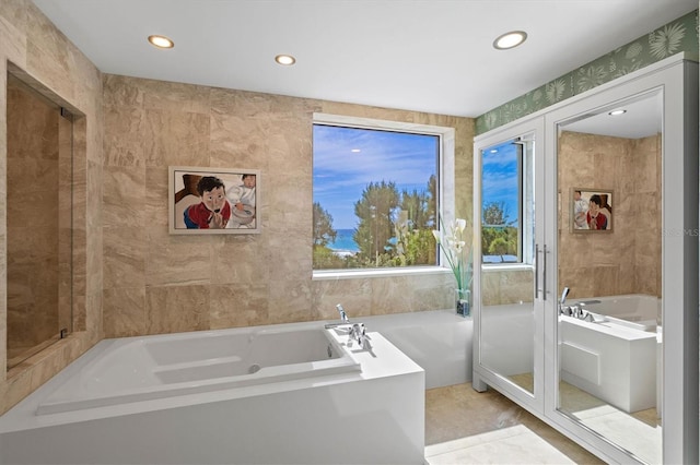 bathroom with a bath and tile walls