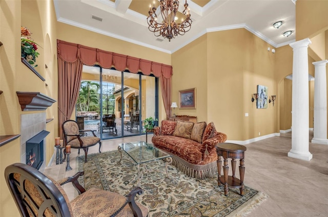 living room featuring ornamental molding, a tile fireplace, a notable chandelier, a towering ceiling, and decorative columns