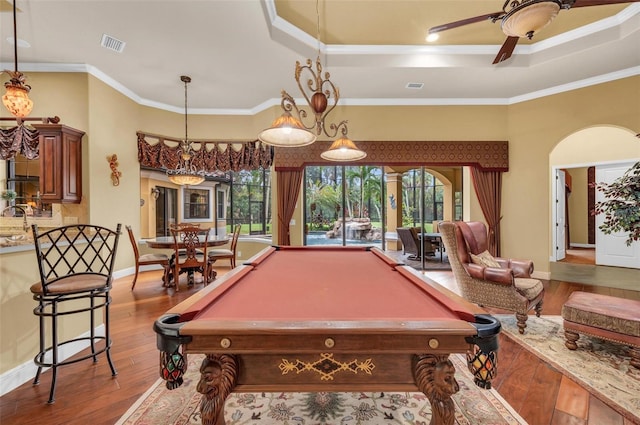 recreation room featuring crown molding, ceiling fan, a tray ceiling, and hardwood / wood-style floors