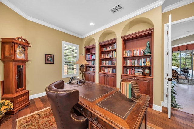 home office featuring ornamental molding, plenty of natural light, built in features, and dark hardwood / wood-style flooring