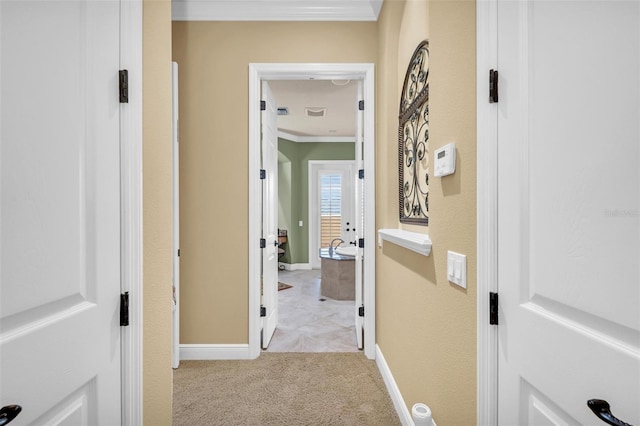 hall featuring light carpet and ornamental molding