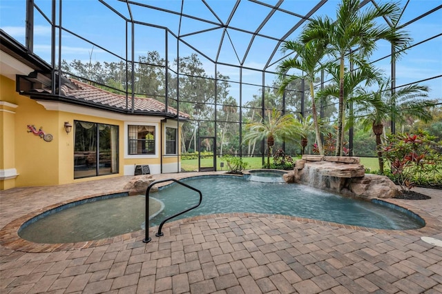 view of pool featuring an in ground hot tub, a lanai, pool water feature, and a patio