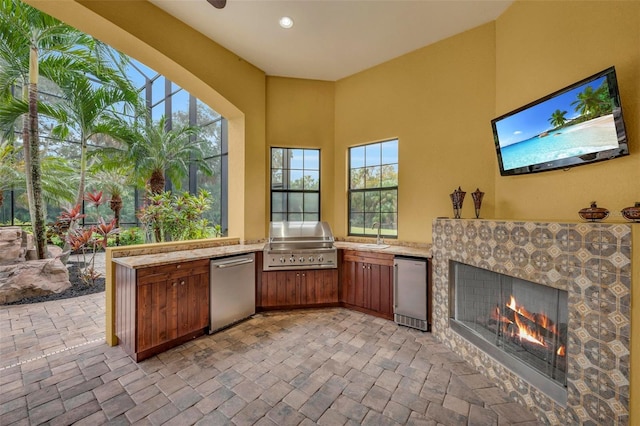 view of patio / terrace with a tiled fireplace, a grill, sink, and area for grilling