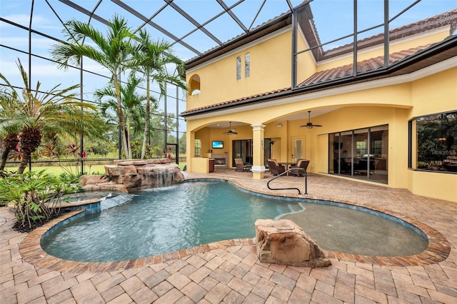 view of swimming pool with glass enclosure, a patio, ceiling fan, and an in ground hot tub