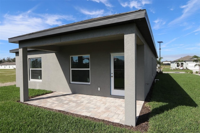 rear view of house featuring a patio area and a yard