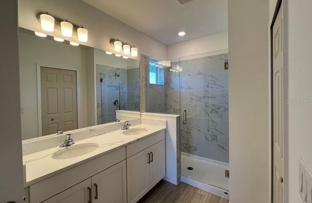 full bathroom with double vanity, a closet, a sink, and a marble finish shower