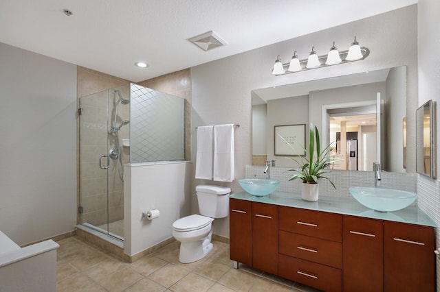 bathroom featuring decorative backsplash, tile patterned floors, vanity, toilet, and a shower with shower door