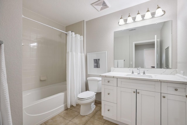 full bathroom featuring vanity, tile patterned flooring, toilet, shower / bath combo with shower curtain, and a textured ceiling