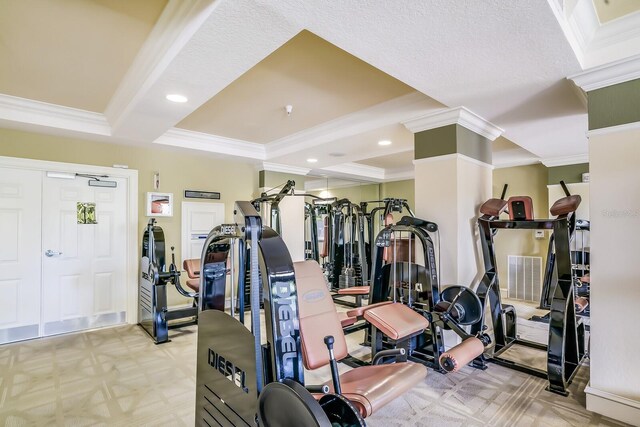 exercise room featuring light colored carpet, ornamental molding, and a textured ceiling