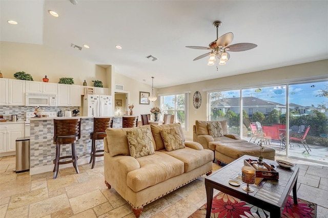 living room with ceiling fan and vaulted ceiling