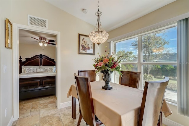 dining space with ceiling fan with notable chandelier and vaulted ceiling