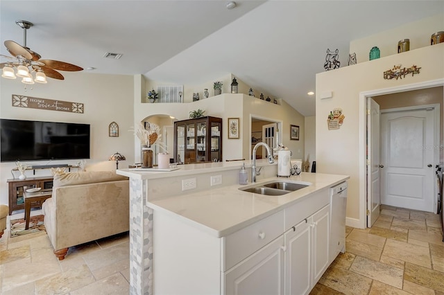 kitchen featuring ceiling fan, a kitchen island with sink, sink, white cabinets, and lofted ceiling