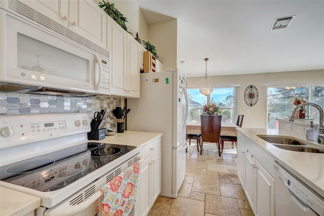 kitchen with white cabinetry, sink, pendant lighting, and white appliances