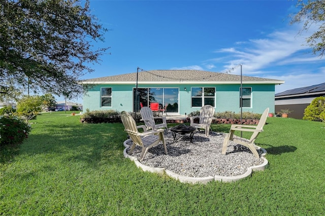 rear view of house with a lawn, a patio area, and a fire pit