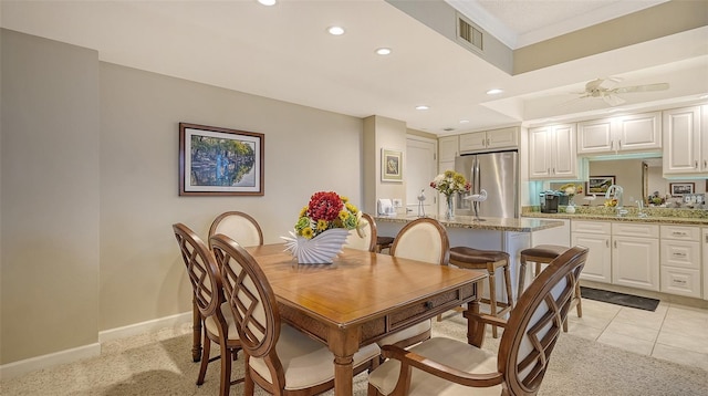 tiled dining room with ceiling fan and sink