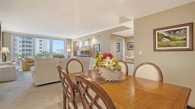 carpeted dining room featuring crown molding and a textured ceiling