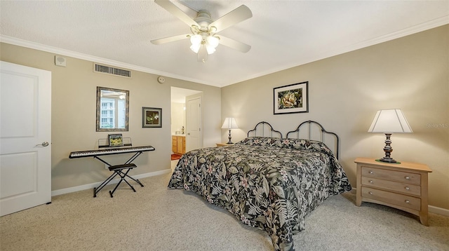 carpeted bedroom featuring ceiling fan, ensuite bathroom, and crown molding