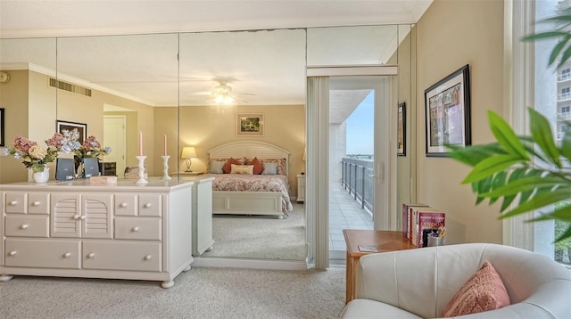 carpeted bedroom with ceiling fan and ornamental molding