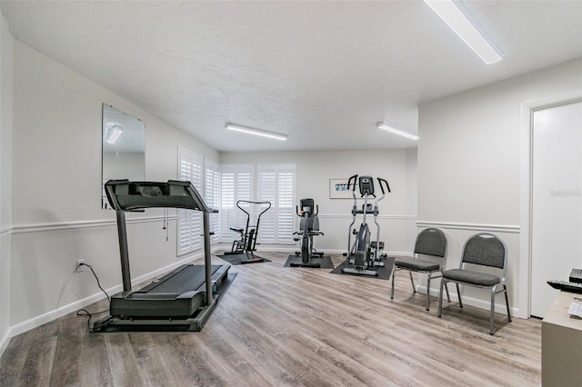 workout room featuring a textured ceiling and light hardwood / wood-style flooring