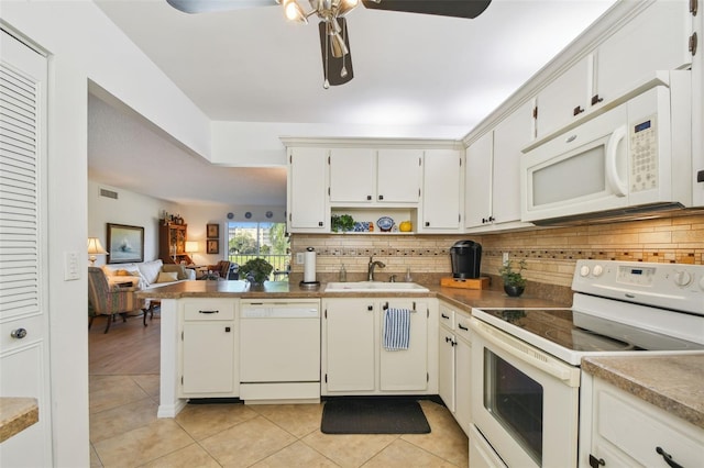 kitchen featuring light tile patterned flooring, white appliances, sink, white cabinetry, and kitchen peninsula