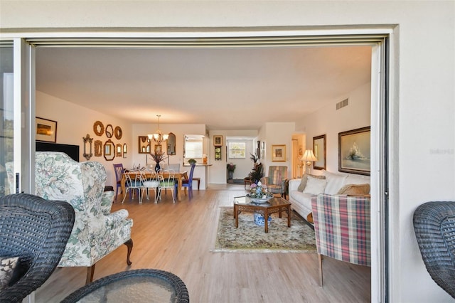 living room with hardwood / wood-style floors and a notable chandelier