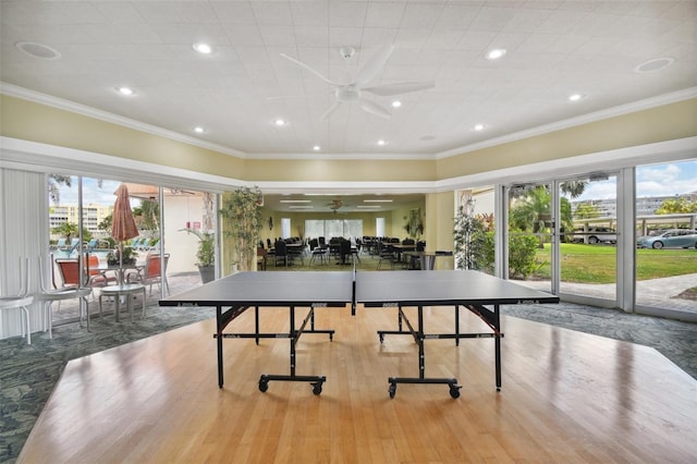 rec room with ceiling fan, light hardwood / wood-style flooring, and ornamental molding